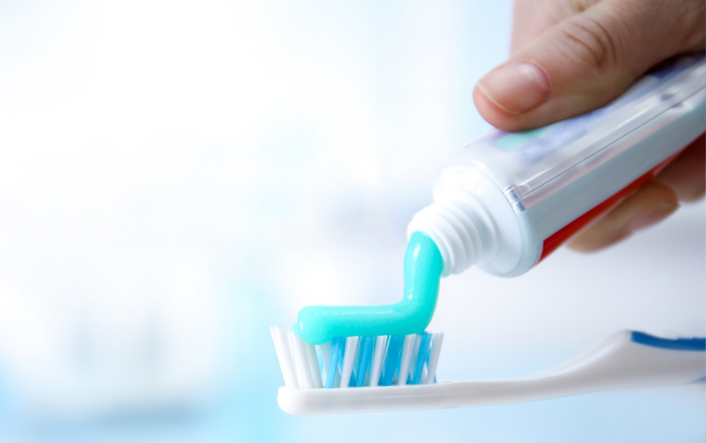 A person is holding a toothbrush and toothpaste.
